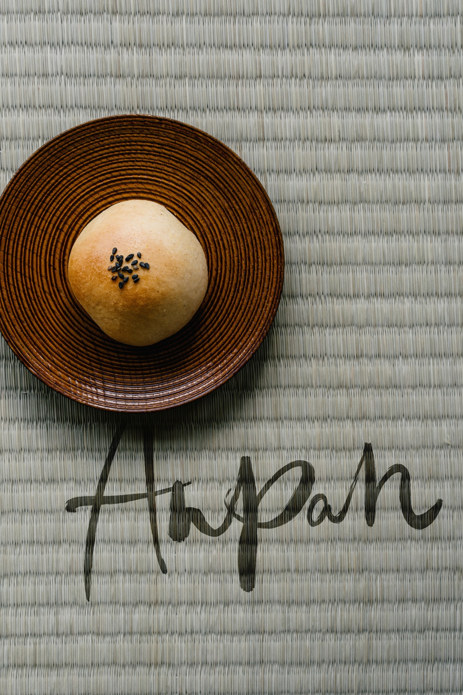 Ein mit Anko gefülltes japanisches Hefebrötchen mit schwarzem Sesam