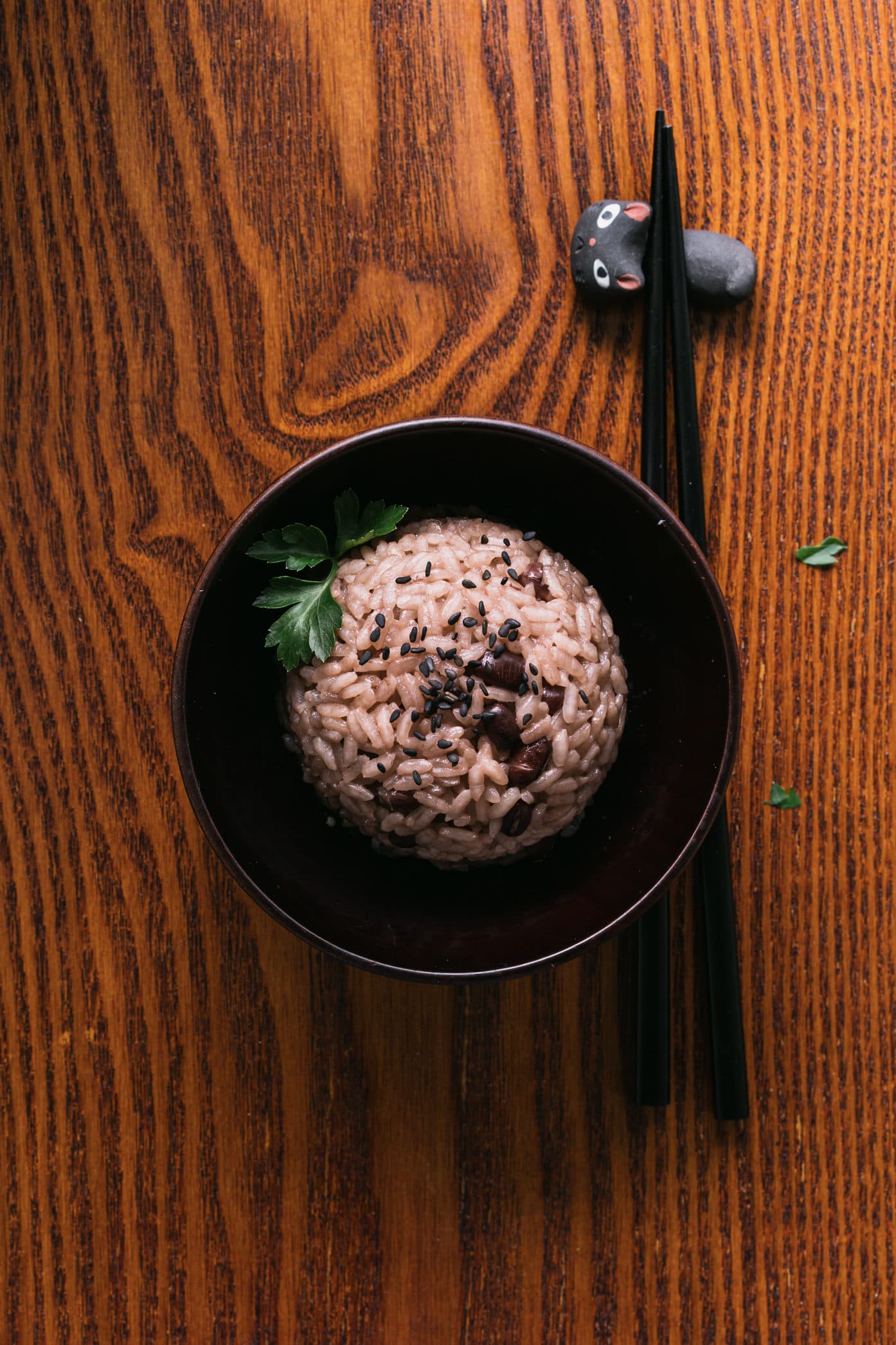 Eine Schale mit rotem Reis und Essstäbchen daneben