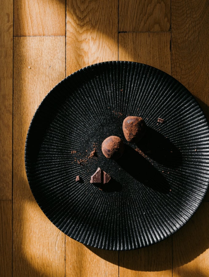 Ein Teller mit zwei Schoko-Protein-Eiern, bestäubt mit etwas Kakao und mit etwas Schokolade